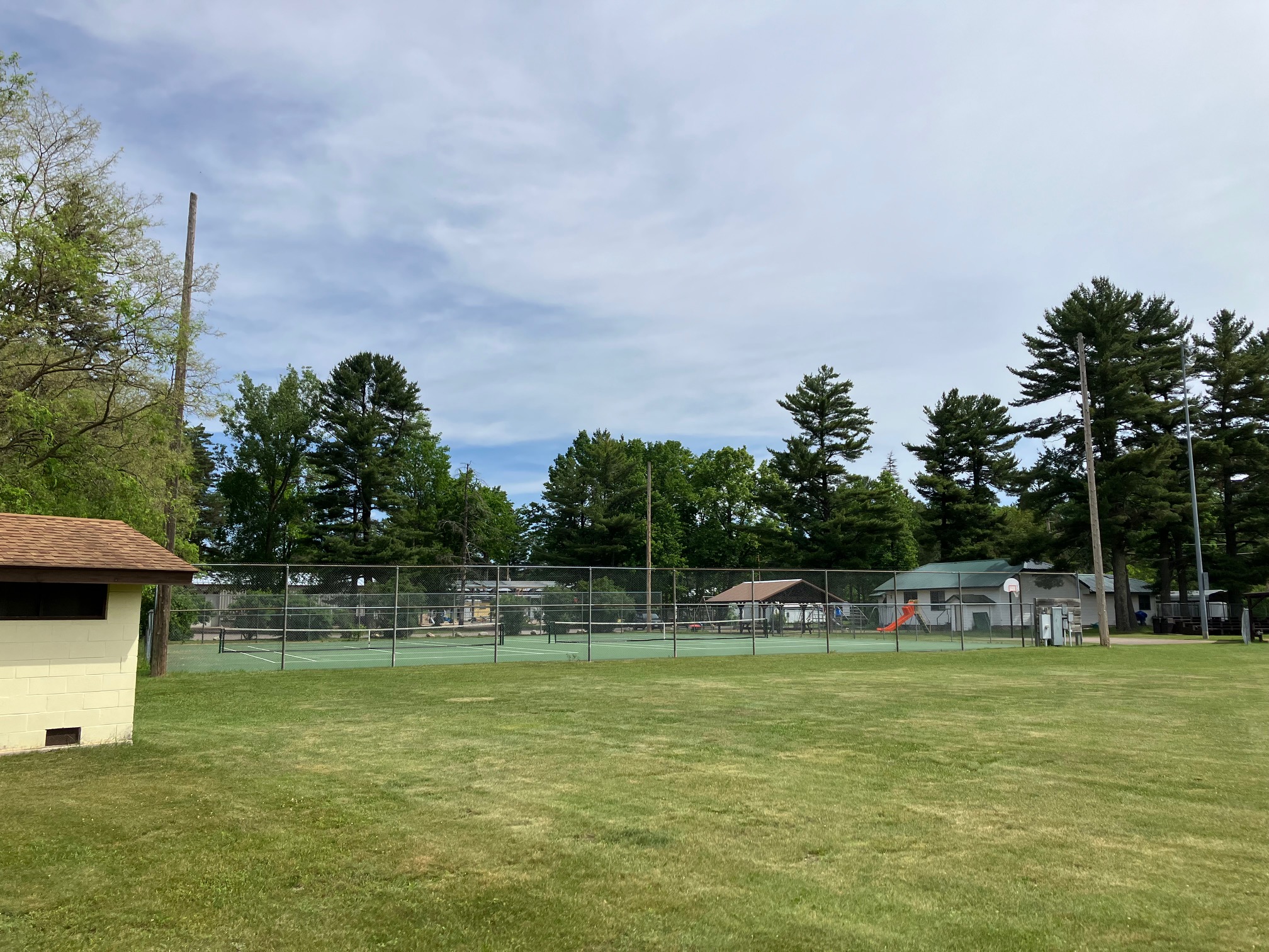 An open recreational sports field ringed by Northwoods pines
